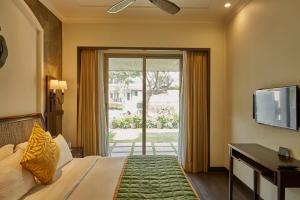 a bedroom with a bed and a sliding glass door at Rhythm Lonavala - An All Suite Resort in Lonavala