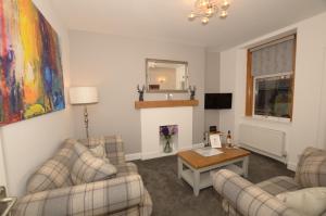 a living room with two couches and a table at The Stags Head Apartment in Inverness