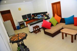 a living room with a couch with colorful pillows at Villa Wanderlust in Hikkaduwa