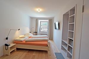 a bedroom with two beds and a window at Albergo Croce Bianca in Poschiavo