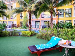 a patio with a chair and a table and a building at Venetian Poseidon Pool Hotel in Jomtien Beach