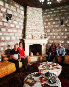 a group of people sitting in a living room with a fireplace at Hotel Berati in Berat