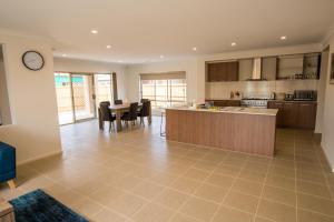 a large kitchen with a counter and a table at Apple House Point Cook in Point Cook