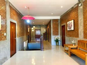 a hallway with a bench and a pink umbrella at Home Inn Pai Garden in Pai