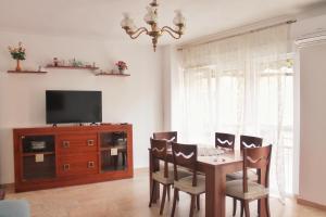 una sala da pranzo con tavolo, sedie e TV di apartment a stone's throw from Santa Barbara ad Alicante