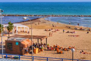 un gruppo di persone su una spiaggia vicino all'oceano di apartment a stone's throw from Santa Barbara ad Alicante