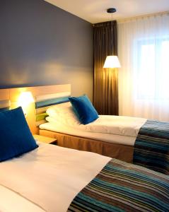 um quarto de hotel com duas camas e uma janela em Thon Hotel Brønnøysund em Brønnøysund