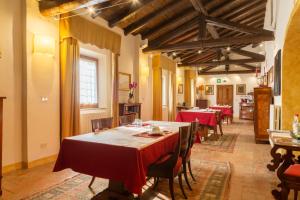 una grande sala da pranzo con tavoli e sedie rossi di Cà Palazzo Malvasia - BolognaRooms a Sasso Marconi
