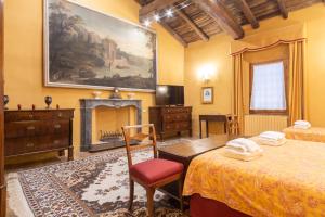 1 dormitorio con 2 camas y chimenea. en Cà Palazzo Malvasia - BolognaRooms en Sasso Marconi