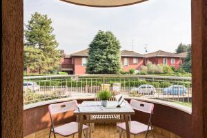 d'une terrasse avec une table et des chaises sur un balcon. dans l'établissement EXPO CITY - BALZAROTTI BUSINESS APARTMENT by ITALYVING, à Rho