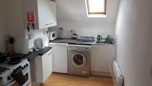 a kitchen with a washing machine and a sink at Quality Accommodation in Leeds