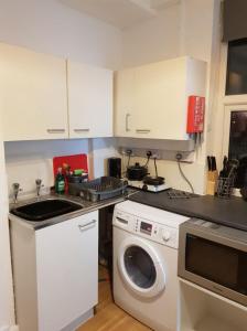 a kitchen with a sink and a washing machine at Quality Accommodation in Leeds