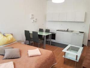 uma cozinha com uma mesa e uma cozinha com armários brancos em Green apartment em Viena