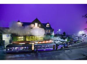 a train in front of a building at night at Zambala Retreat & Spa Darjeeling in Darjeeling