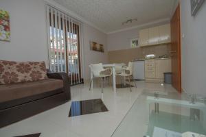 een woonkamer met een bank en een tafel met stoelen bij Apartmani Milena in Herceg-Novi