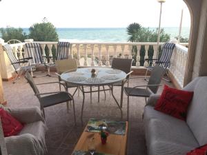 un patio con mesa, sillas y el océano en Seafront Dream Apartment, en Torrevieja
