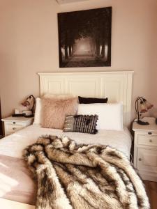 a bedroom with a white bed with a furry blanket on it at Glenview Retreat Luxury Accommodation in Emerald