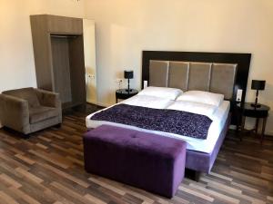 sypialnia z dużym łóżkiem i fioletową otomaną w obiekcie Hotel Pension Baron am Schottentor w Wiedniu