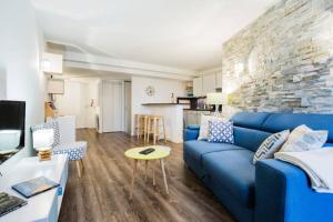 a living room with a blue couch and a stone wall at LEYDET in Aix-en-Provence