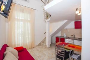 a living room with a red couch and a table at Apartments Lara in Podgora
