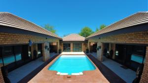 a swimming pool in the courtyard of a house at Ubuntu Bed and Breakfast in Marloth Park