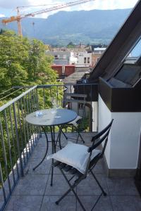 un patio con tavolo e sedie sul balcone. di Hager Apartment 2 a Merano