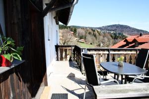 patio con mesa y sillas en el balcón en Ferienwohnung auf dem Erlebnisreiterhof Kreipl, en Grattersdorf