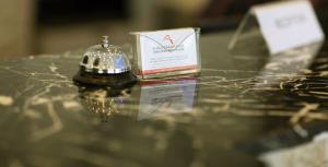 a table with a bell and a box on it at Asfar Hotel Apartments أسفار للشقق الفندقية in Muscat