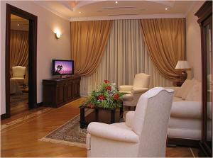 uma sala de estar com duas cadeiras e uma televisão em AYF Palace em Baku