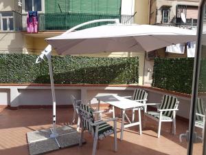 uma mesa e cadeiras com um guarda-sol numa varanda em 'O Vascio Vomero em Nápoles