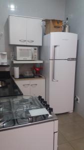 eine Küche mit einem Herd und einem weißen Kühlschrank in der Unterkunft Apartamento 2Quartos PraiaMetro Copacabana in Rio de Janeiro