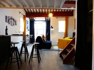 uma sala de estar com um bar e um sofá amarelo em Les Bernardines em Aix-en-Provence