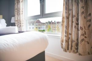 a bedroom with a bed and a window at Lochend Park View Apartment in Edinburgh