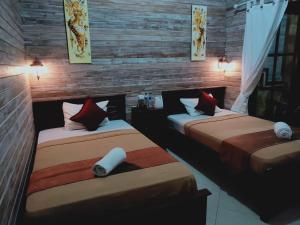 two beds in a room with wooden walls at Tiki bar and more in Nusa Lembongan +65 photos