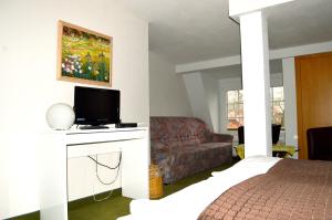 布科的住宿－Strandhotel Buckow gut-Hotels SEE，一间卧室配有一张床和一张沙发