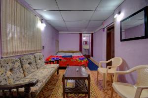 a living room with a couch and a bed at Chuppi Homestay in Madikeri