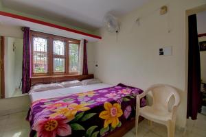 1 dormitorio con 1 cama, 1 silla y 1 ventana en Chuppi Homestay en Madikeri