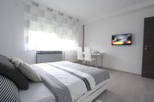 a bedroom with a bed and a table and a television at Imperium Rooms Zagreb Airport in Velika Gorica