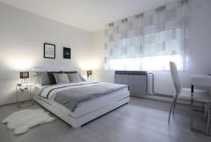 Un dormitorio blanco con una cama blanca y un escritorio. en Imperium Rooms Zagreb Airport, en Velika Gorica