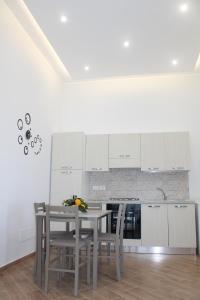 a kitchen with white cabinets and a table and chairs at Sunset House in Massa Lubrense