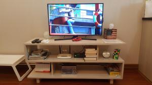un televisor sentado en la parte superior de un estante blanco en Papilukas Room Kalibata City - Studio Silver, en Yakarta