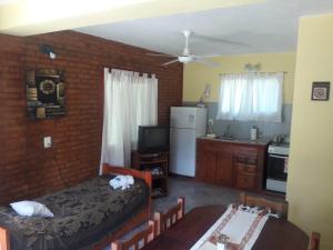 sala de estar con cama y cocina en Cabañas Peñihue en Carpintería