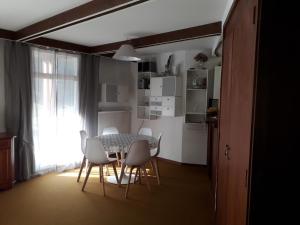 ラ・モンジーにあるGrand appartement Béro Bistoのダイニングルーム(テーブル、白い椅子付)