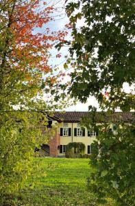 a building in the middle of a field with trees at Cascina San Giorgio in Valenza