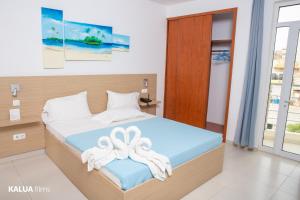 a bedroom with a bed with towels on it at Hotel Cesaria in Praia