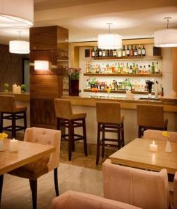 un restaurante con bar, mesas y sillas en Dovitel Boutique Hotel en Ioánina