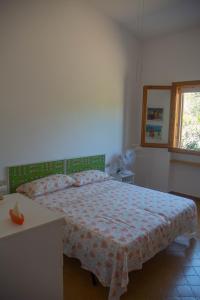 a bedroom with a bed and a table and a window at Veranda Piau in Tertenìa
