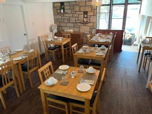 uma sala de jantar com mesas e cadeiras de madeira em Loch Eyre House em Portree