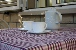 un tavolo con due tazze e una teiera sopra di Apartments Pino a Makarska