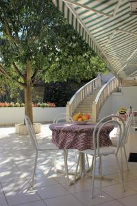 una mesa y sillas con un bol de fruta. en Apartments Pino, en Makarska